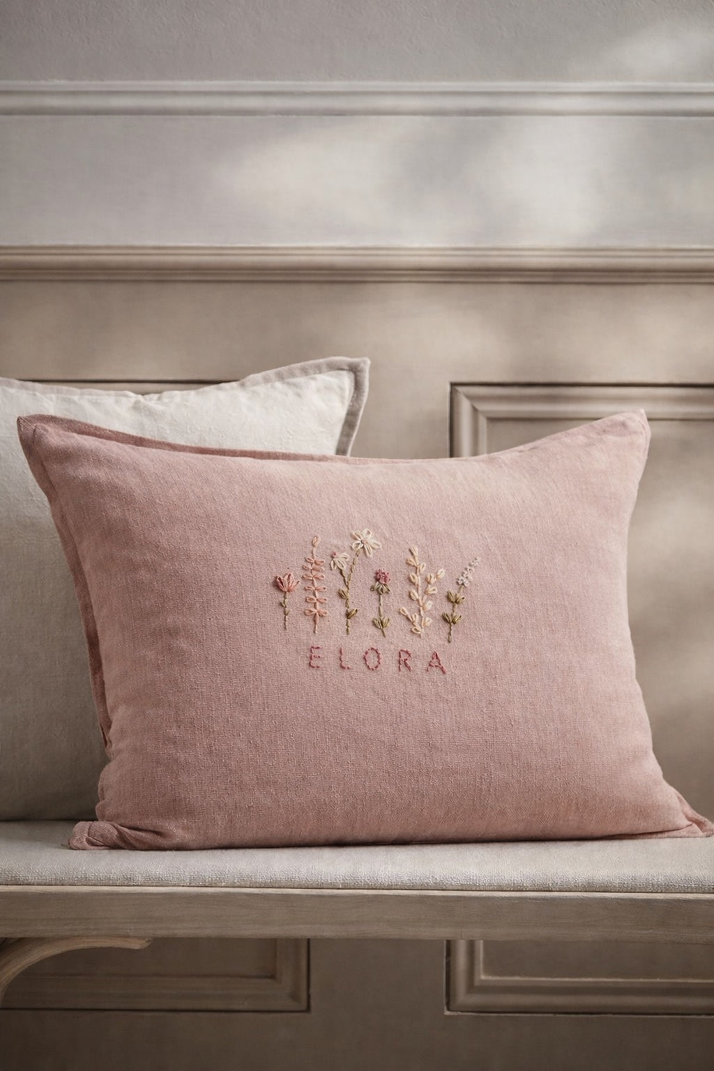 Pink pillow with embroidered design and text on a neutral background- personalised baby / toddler gift.