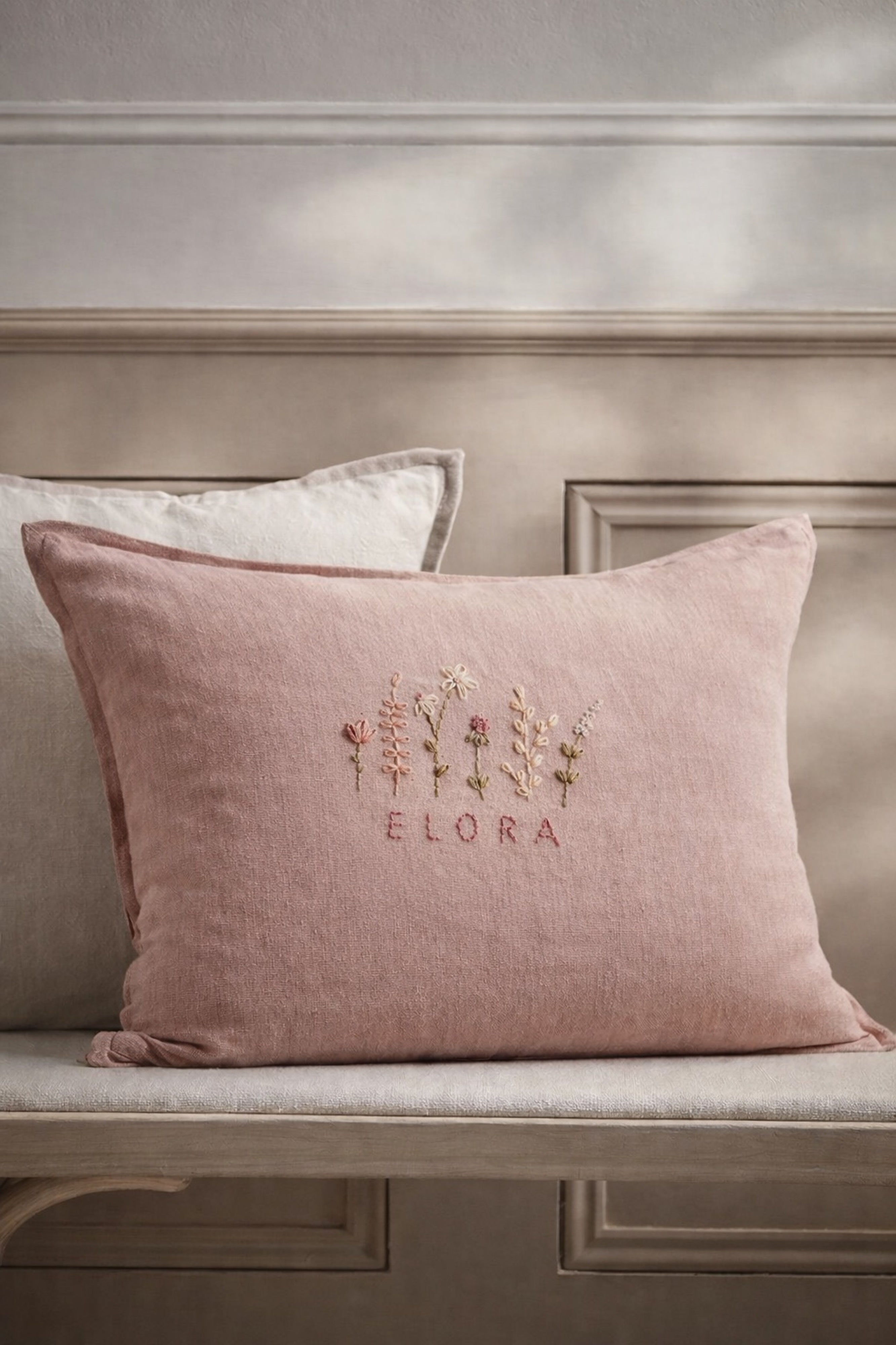 Pink pillow with embroidered design and text on a neutral background- personalised baby / toddler gift.
