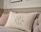 Decorative pillow with floral embroidery and text on a bed- personalised baby / toddler gift.