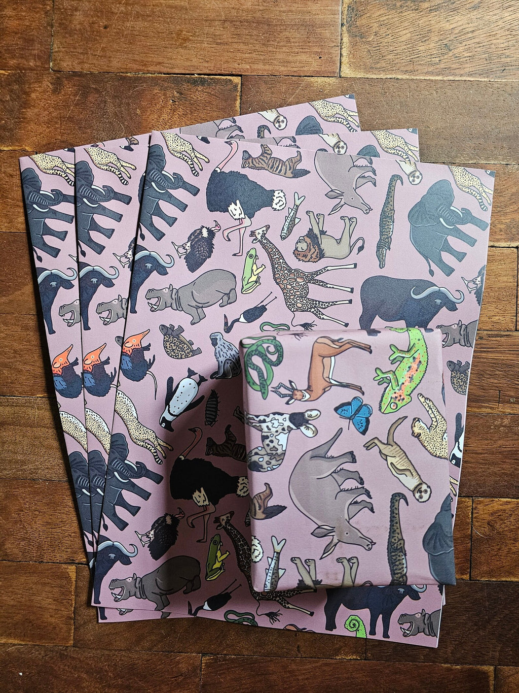 Two folded fabric swatches with animal pattern on a wooden surface