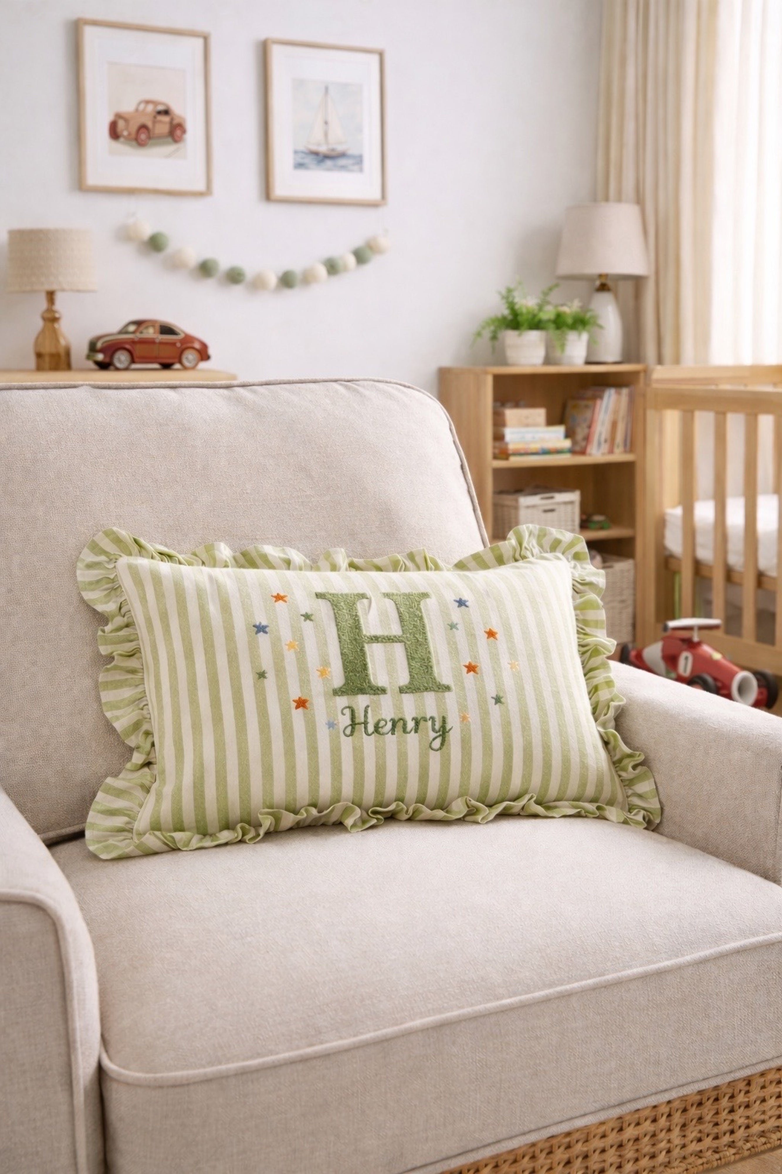 Green striped pillow with a name embroidered on a beige couch in a home setting  -  personalised baby / toddler gift.