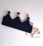 Black bra with decorative straps and pom-poms on a white background.