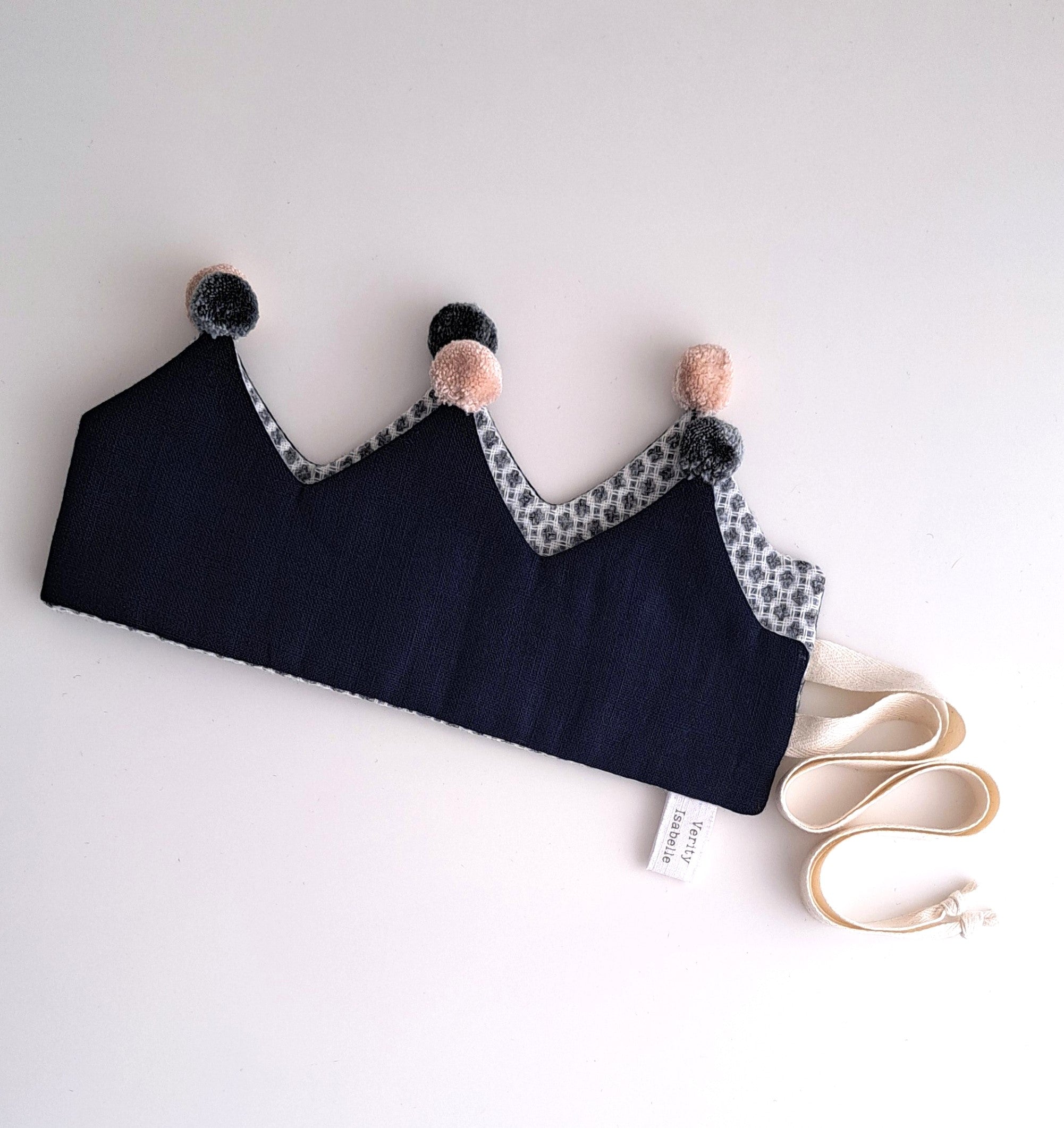 Black bra with decorative straps and pom-poms on a white background.