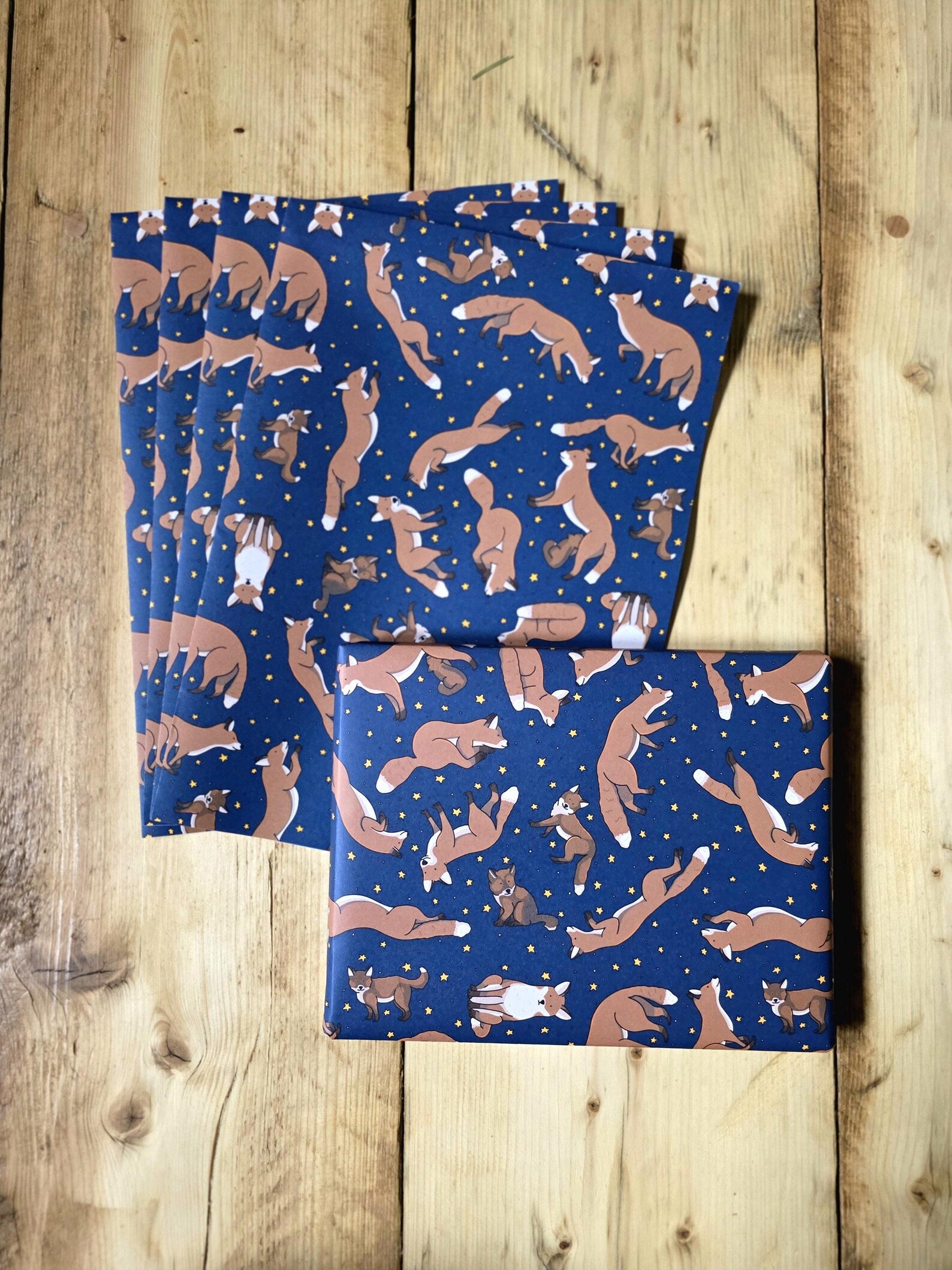 Set of blue wrapping paper sheets with animal pattern on a wooden surface