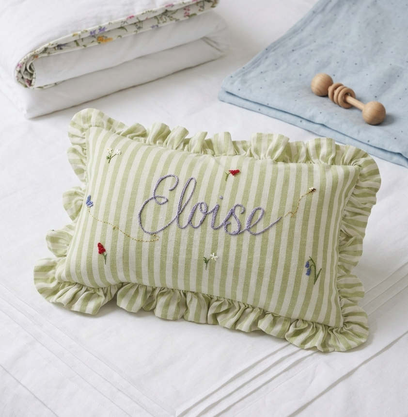 Green striped pillow with a name embroidery on a white surface  -  personalised baby / toddler gift.