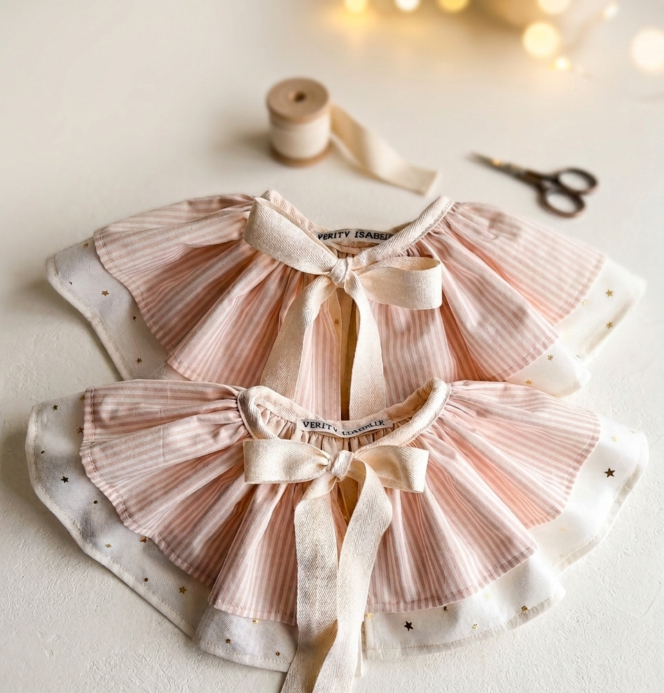Pink and white ruffled collar with ribbons on a light background -  baby / toddler gift.