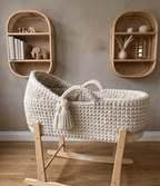 Woven baby crib with wooden stand in a room with wicker shelves