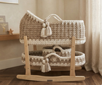 Wooden crib with knitted canopy in a home setting