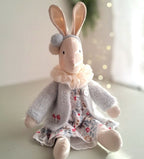 Stuffed rabbit toy wearing a floral dress on a light background- heirloom baby/toddler gifts.